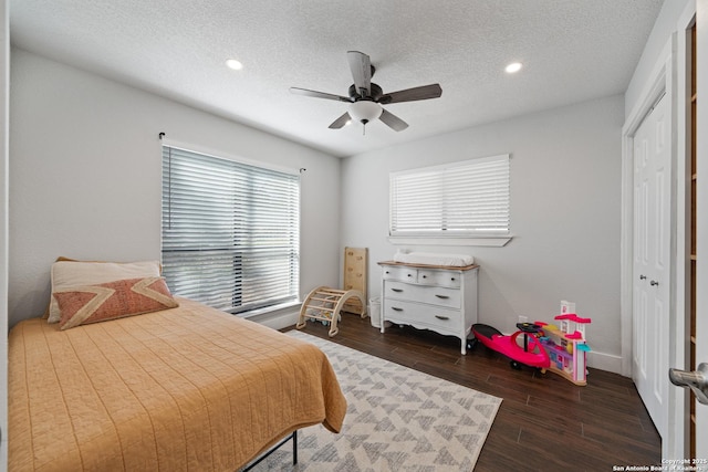 bedroom with recessed lighting, dark wood-style flooring, ceiling fan, a closet, and a textured ceiling