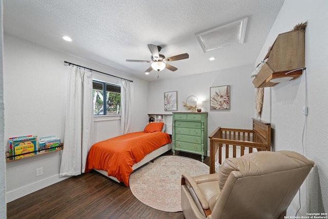 bedroom with a textured ceiling, dark wood finished floors, recessed lighting, baseboards, and attic access