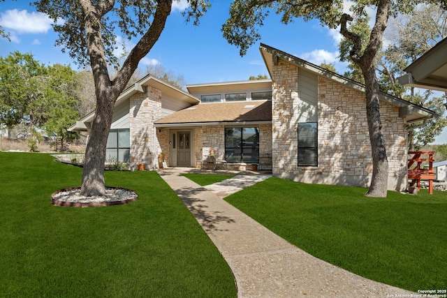 mid-century home featuring stone siding and a front lawn