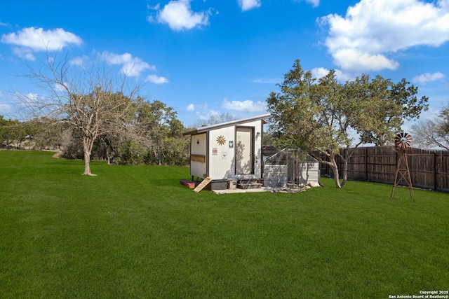 view of yard with an outbuilding, a storage shed, and fence