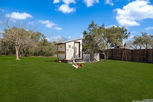 view of yard featuring an outbuilding, a storage shed, and a fenced backyard