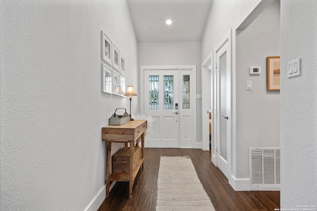 interior space featuring dark wood-style floors, visible vents, baseboards, and a textured wall