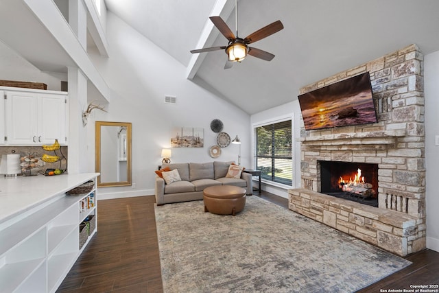 living area featuring dark wood finished floors, visible vents, a stone fireplace, and high vaulted ceiling