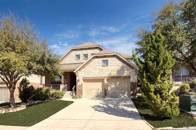 view of front of home with concrete driveway, brick siding, covered porch, and stone siding