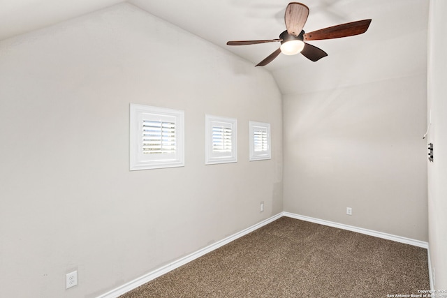 empty room with baseboards, a ceiling fan, lofted ceiling, and dark colored carpet