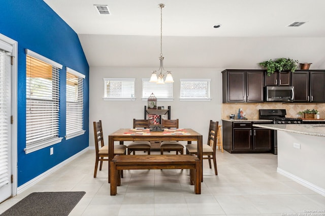 dining space with vaulted ceiling, baseboards, visible vents, and a chandelier