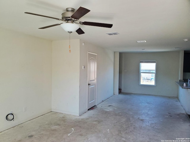 spare room with a ceiling fan, baseboards, visible vents, and concrete floors