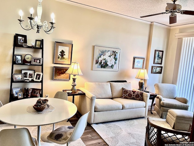 living area with ceiling fan with notable chandelier, a textured ceiling, crown molding, and wood finished floors