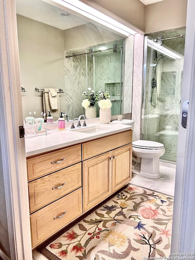 bathroom with vanity, toilet, and a marble finish shower