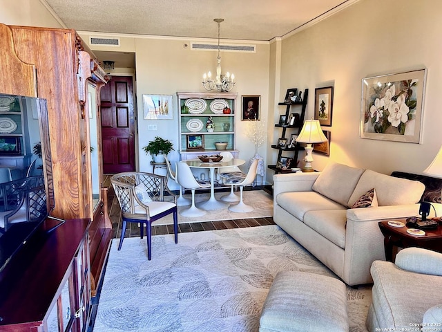 living room with visible vents, a notable chandelier, wood finished floors, and a textured ceiling