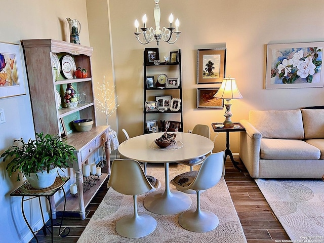 dining room featuring dark wood finished floors, a notable chandelier, and baseboards