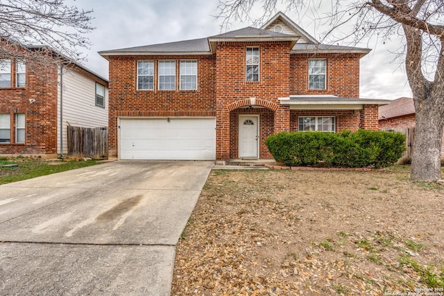 view of front facade with brick siding, an attached garage, driveway, and fence