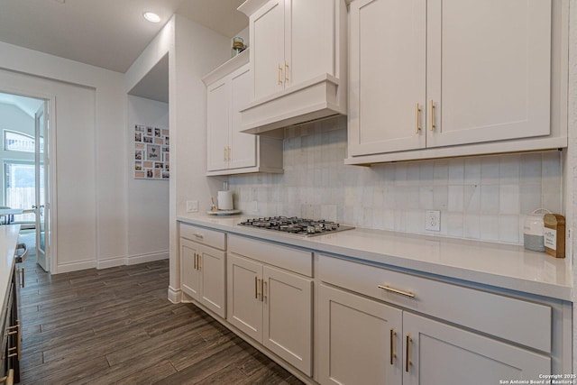 kitchen featuring dark wood-type flooring, tasteful backsplash, white cabinetry, stainless steel gas stovetop, and light countertops