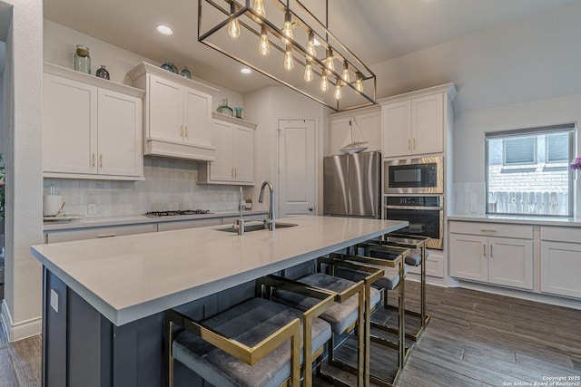 kitchen featuring a sink, decorative backsplash, appliances with stainless steel finishes, and custom range hood