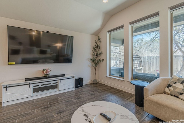 living room with baseboards, lofted ceiling, and dark wood-type flooring