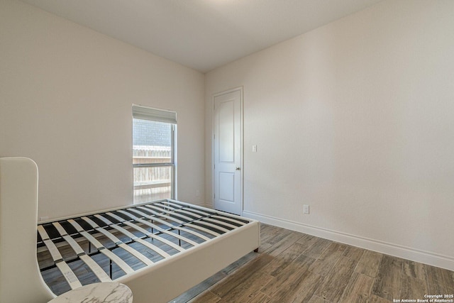 unfurnished bedroom with baseboards and wood finished floors