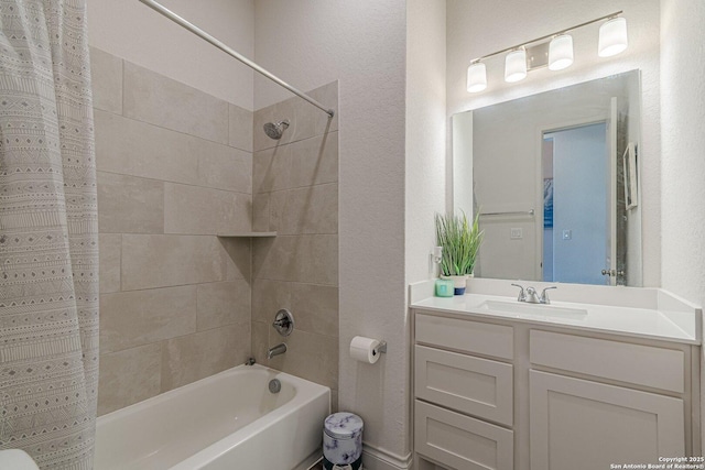 bathroom featuring shower / bath combo with shower curtain, vanity, and a textured wall