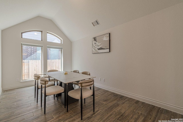 dining space with visible vents, lofted ceiling, baseboards, and wood finished floors