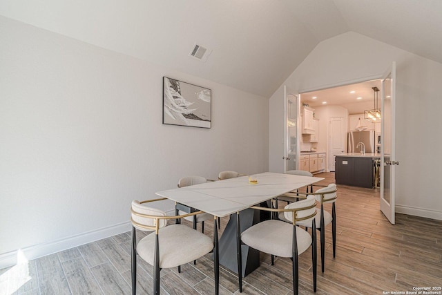 dining space with visible vents, baseboards, and light wood-style floors