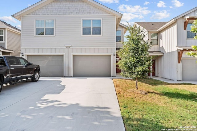 view of front of property featuring driveway, a front lawn, board and batten siding, and an attached garage