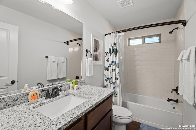 bathroom featuring vanity, toilet, shower / bath combo, and visible vents