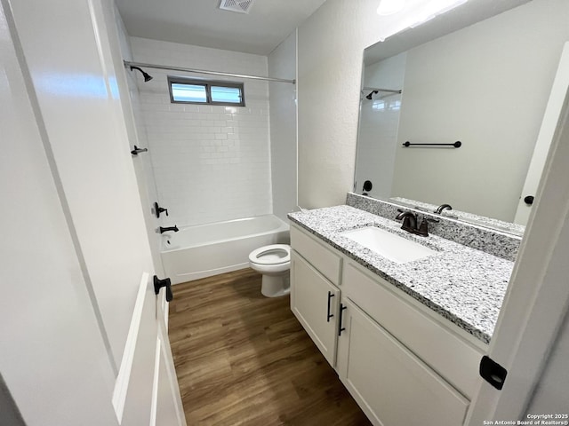 bathroom featuring visible vents, toilet, wood finished floors,  shower combination, and vanity