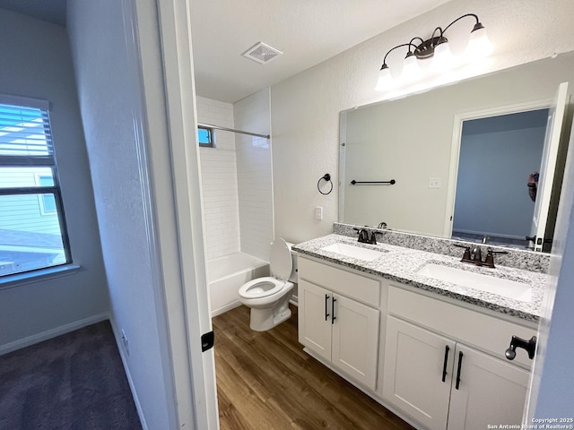 bathroom featuring double vanity, visible vents, wood finished floors, and a sink