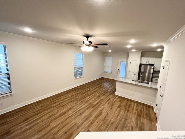 unfurnished living room featuring a ceiling fan, dark wood-style floors, recessed lighting, crown molding, and baseboards