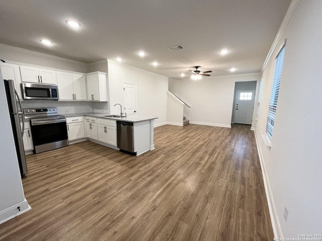 kitchen featuring visible vents, open floor plan, appliances with stainless steel finishes, a peninsula, and a sink