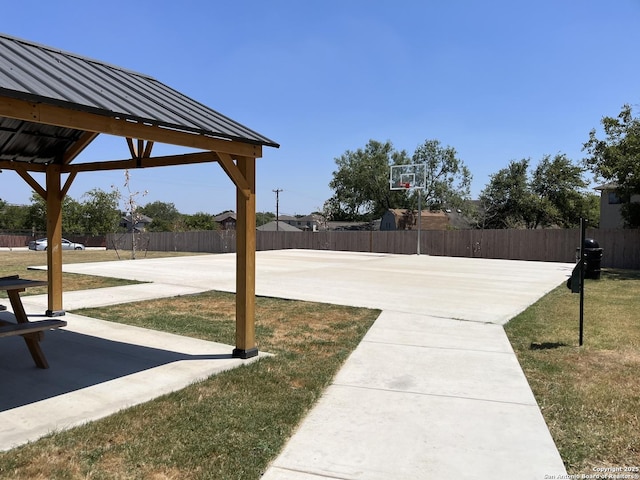 view of patio with basketball court and fence