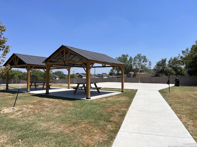 view of property's community featuring a gazebo, a lawn, and fence