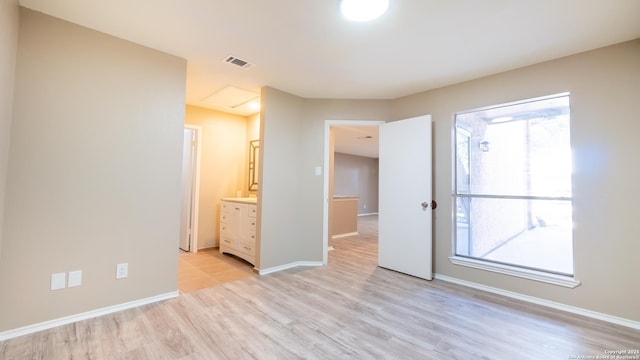 unfurnished bedroom featuring visible vents, multiple windows, baseboards, and light wood-style flooring