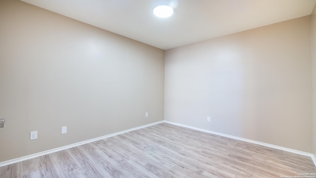 spare room with light wood-type flooring and baseboards