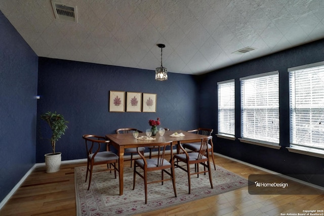 dining room featuring visible vents, baseboards, and wood finished floors