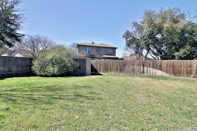 view of yard featuring an outbuilding, a fenced backyard, and a shed