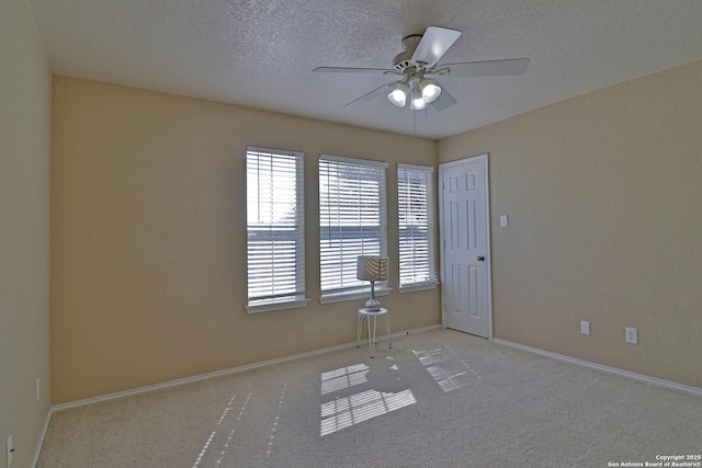 spare room featuring ceiling fan, carpet, baseboards, and a textured ceiling