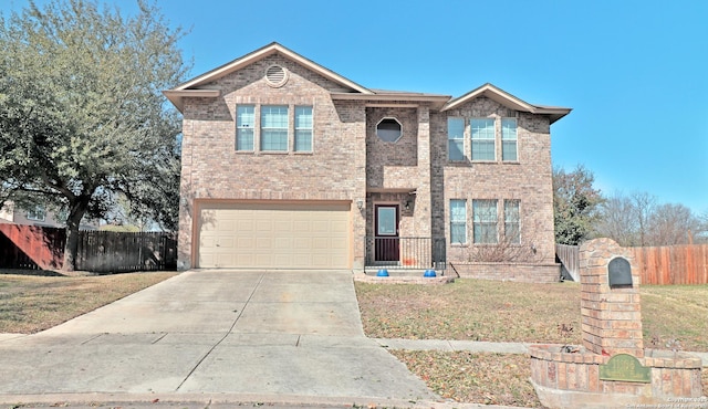 traditional-style home featuring a front yard, fence, driveway, a garage, and brick siding