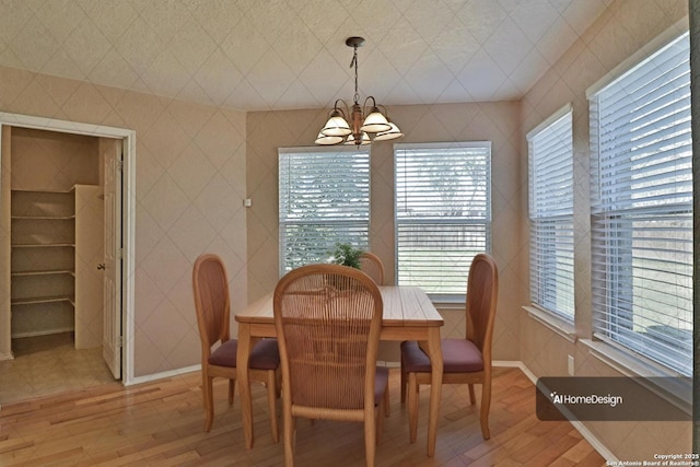 dining area featuring tile walls, a notable chandelier, and light wood finished floors