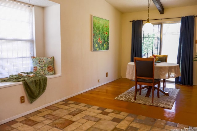 dining area with beamed ceiling, baseboards, and wood finished floors