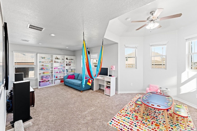 rec room with a ceiling fan, baseboards, visible vents, carpet floors, and a textured ceiling