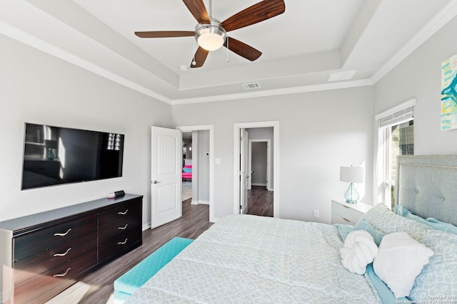 bedroom with a raised ceiling, visible vents, dark wood-style flooring, and baseboards