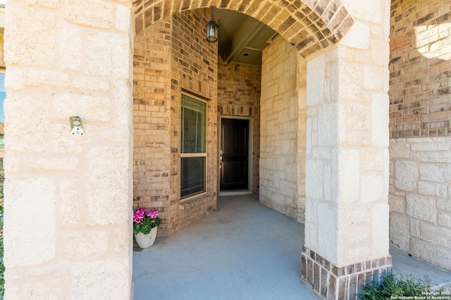 doorway to property with brick siding and stone siding