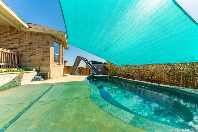 view of pool with a fenced in pool, a patio, a water slide, and a fenced backyard