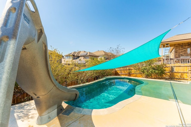 view of swimming pool featuring a fenced in pool, a patio, a water slide, and a fenced backyard