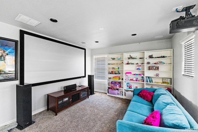 carpeted home theater room with visible vents and baseboards