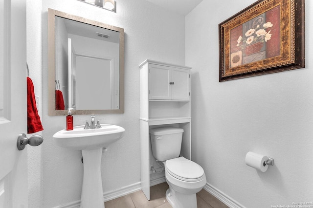 bathroom featuring tile patterned floors, visible vents, baseboards, and toilet