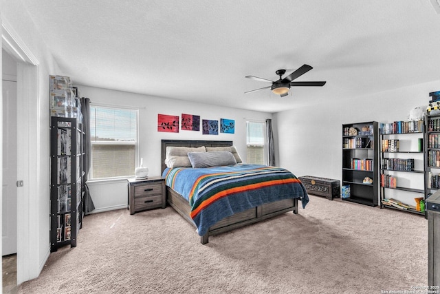 bedroom with ceiling fan, carpet floors, and a textured ceiling