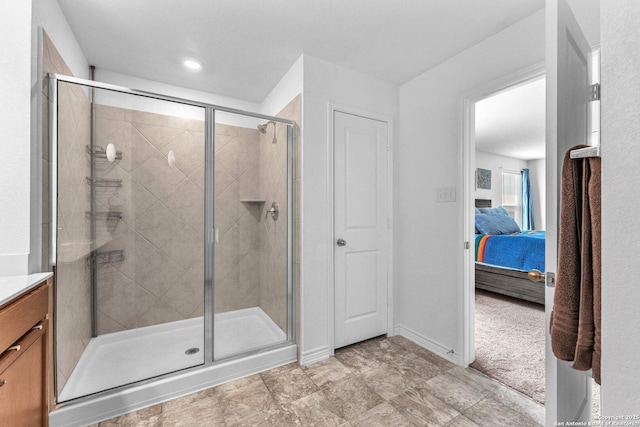 ensuite bathroom featuring vanity, ensuite bath, baseboards, and a stall shower