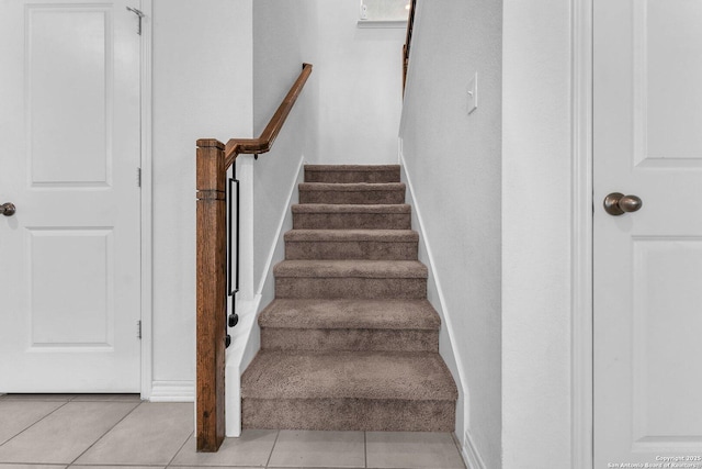 stairway featuring tile patterned flooring and baseboards