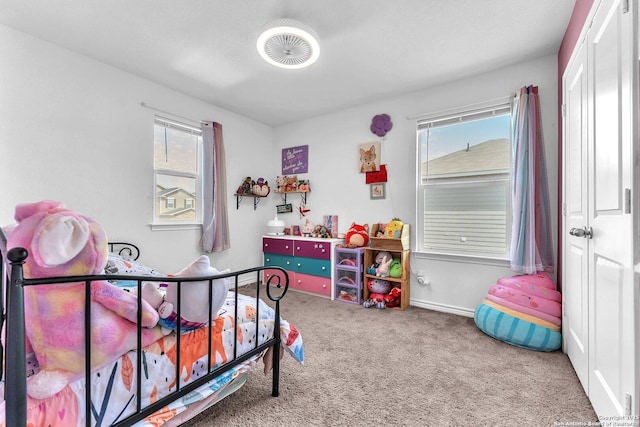 carpeted bedroom with baseboards and multiple windows